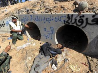 La cache présumée de Mouammar Kadhafi. Sur le mur est inscrit en bleu : « Ceci est la cache de Kadhafi, le rat. Dieu est le plus grand. »