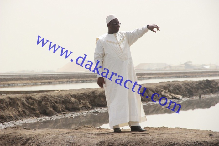 Macky traverse une passerelle d'un mètre de large pour rencontrer un travailleur des salins du Sine-Saloum