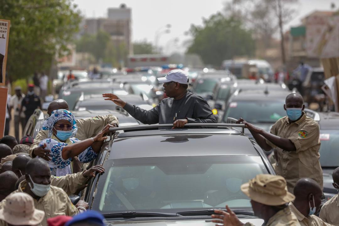 Kaolack : Le président Macky Sall installe confortablement Mariama Sarr sur son véhicule et salue ses alliés.